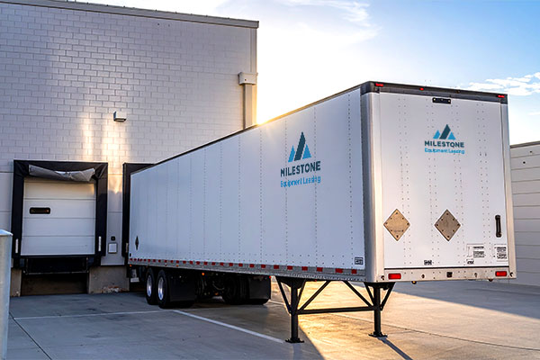 Milestone trailer backed into dock symbolizing tariff transportation impact