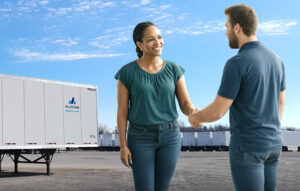 Milestone team member shaking hands with customer near trailer lot