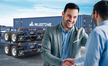Business professionals shaking hands in front of stacked Milestone chassis and containers, representing nationwide chassis leasing solutions.